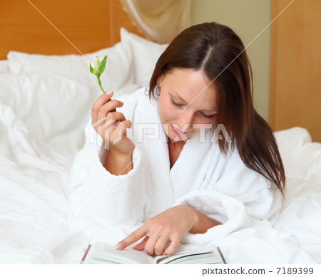 young woman in bed reading a book young woman in bed reading a book 7189399