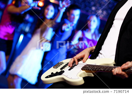 Young guitar player performing in night club 7190714