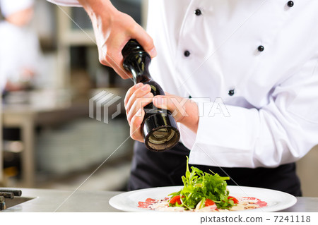 Chef in hotel or restaurant kitchen cooking 7241118