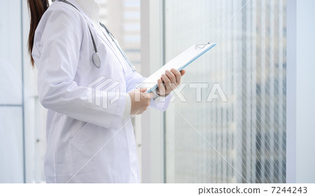 Doctor standing by the window Doctor standing by the window 7244243