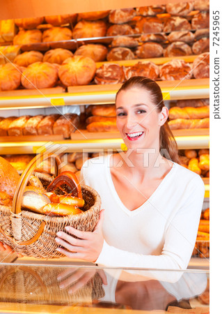 Female baker selling bread in her bakery 7245965