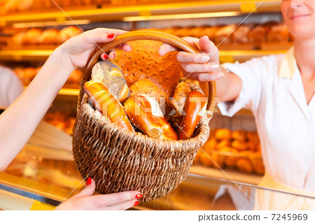 Salesperson with female customer in bakery 7245969
