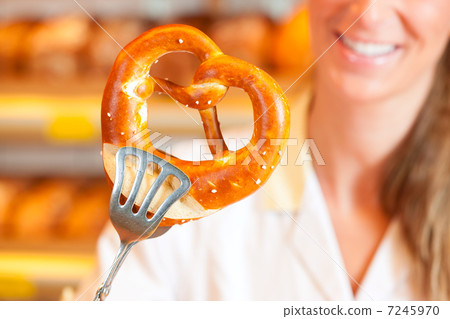 Salesperson is packing bread in bakery Salesperson is packing bread in bakery 7245970