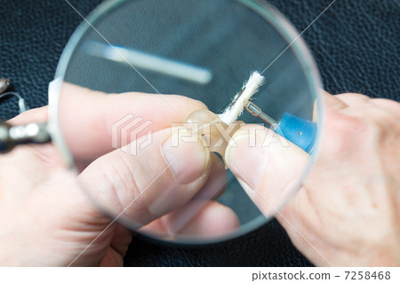 Acoustician working on a hearing aid Acoustician working on a hearing aid 7258468