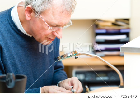 Acoustician working on a hearing aid 7258470