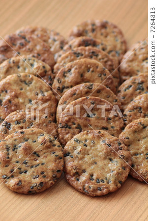 Soy sauce flavored sesame rice crackers arranged on a wooden plate 7264813