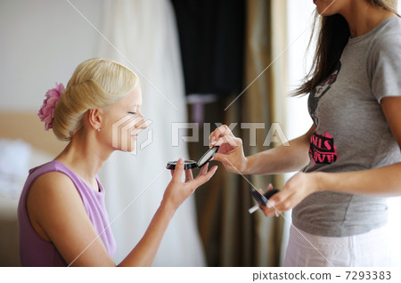 Young beautiful bride applying wedding make-up 7293383