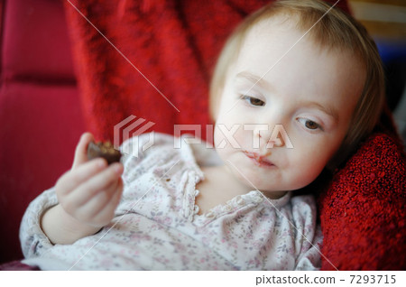 Little toddler girl eating chocolate 7293715