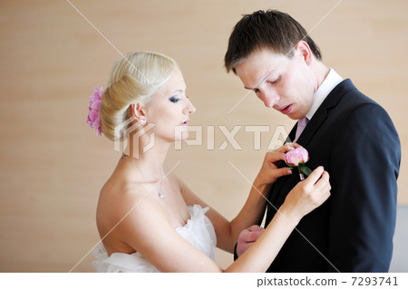 Bride adjusting grooms boutonniere Bride adjusting grooms boutonniere 7293741