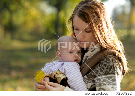 Young mother with her baby in a carrier 7293882