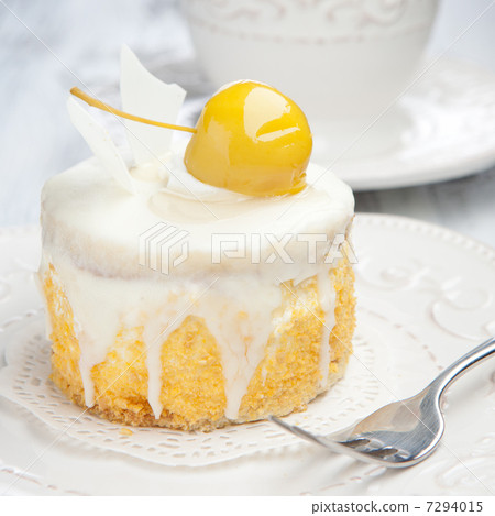 Sweet cake with cup of tea on white wooden table 7294015
