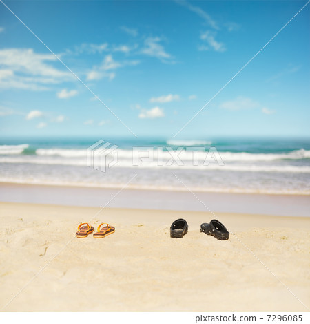 Flip-flops on a sand of the tropical beach. Shallow depth of fie Flip-flops on a sand of the tropical beach. Shallow depth of fie 7296085