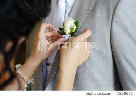 Bride adjusting grooms boutonniere 7298673