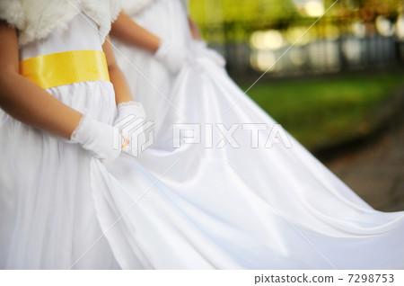 Bridesmaids holding brides wedding dress 7298753