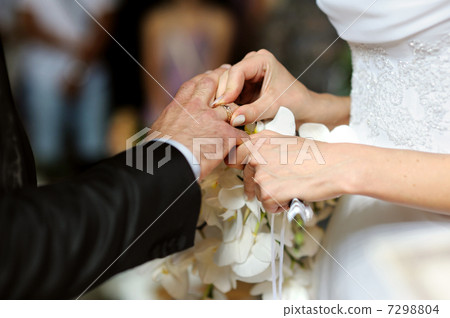 Bride putting the ring on grooms finger Bride putting the ring on grooms finger 7298804