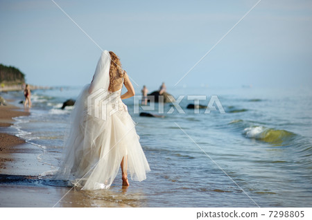 Bride walking along sea coast Bride walking along sea coast 7298805