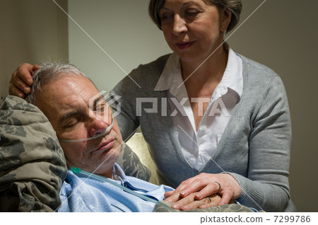 Caring nurse with sleeping senior male patient 7299786