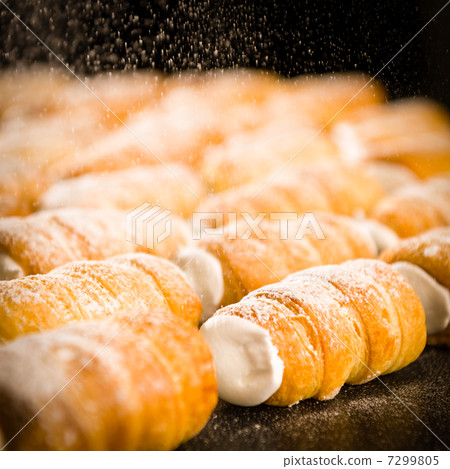 Powder sugar falling on to cream horns 7299805