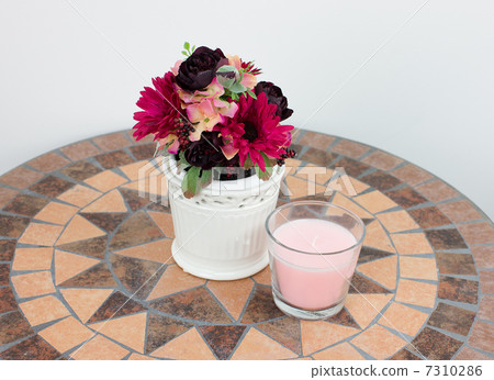 Artificial flowers and aroma candles on the table 7310286