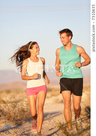 Runners - Active fitness couple running laughing 7310635