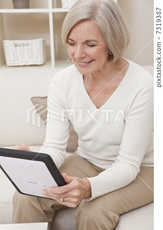 Attractive Senior Woman Using a Tablet Computer Attractive Senior Woman Using a Tablet Computer 7319387