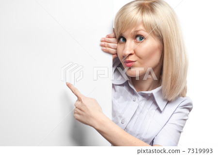 Attractive smiling woman holding white empty paper and pointing Attractive smiling woman holding white empty paper and pointing 7319993