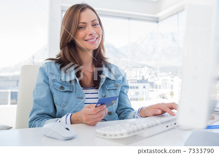 Attractive woman purchasing online with her credit card 7333790
