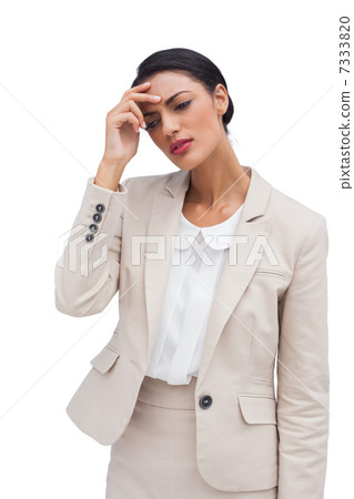 Worried young businesswoman holding her head 7333820