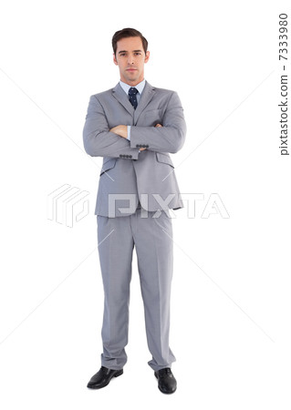 Serious businessman standing with his arms crossed 7333980