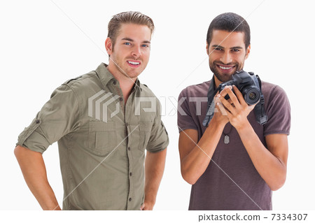 Stylish friends smiling with one holding camera 7334307