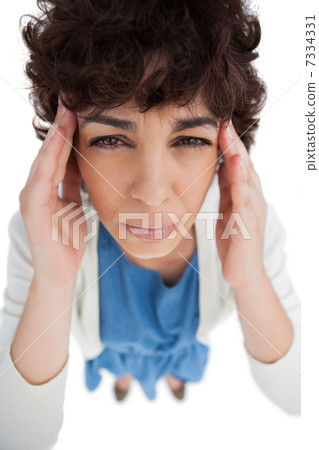 Overhead of woman with a headache touching her temples Overhead of woman with a headache touching her temples 7334331