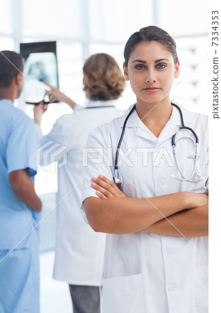 Serious woman doctor with arms crossed looking at the camera Serious woman doctor with arms crossed looking at the camera 7334353