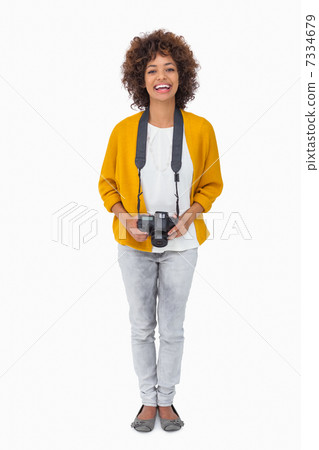 Smiling girl holding digital camera and looking at camera 7334679