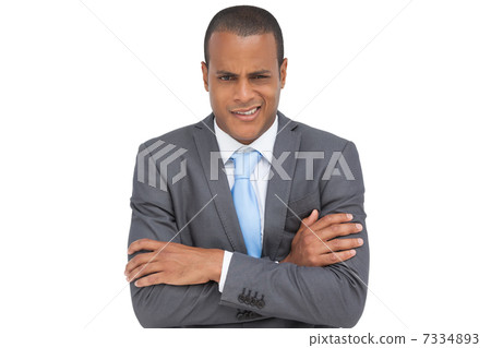 Doubtful young businessman with arms crossed 7334893