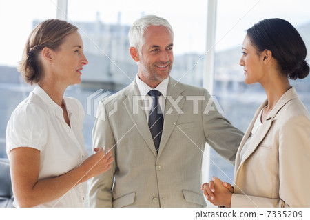 Likeable businessman speaking with female colleagues 7335209