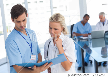 Two doctors examining a file Two doctors examining a file 7335256
