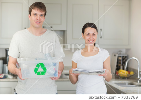 Couple holding recycling bin and newspapers 7335769