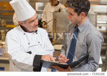 Waiter and chef discussing the menu Waiter and chef discussing the menu 7336188