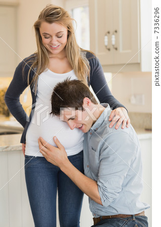 Man listening to stomach of pregnant woman 7336296