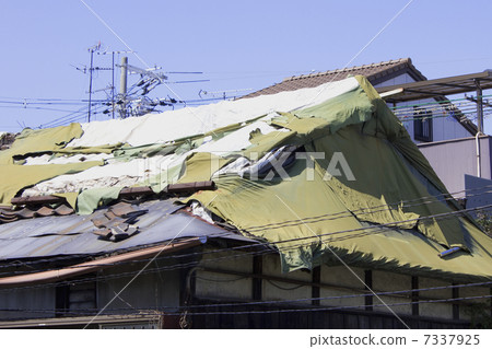 Sheet stretched over the roof of a private house with leakage 7337925