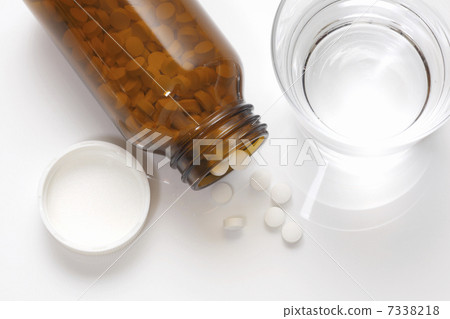 Drug bottle with tablets and cup water 7338218