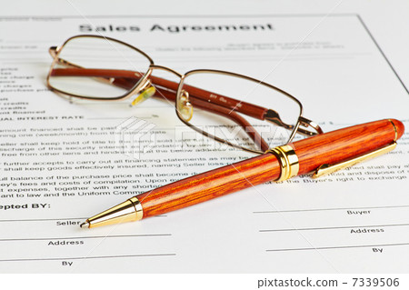 Contract with glasses and wooden pen ready to be signed Contract with glasses and wooden pen ready to be signed 7339506