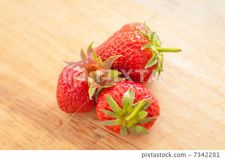 three strawberries on wooden table 7342281