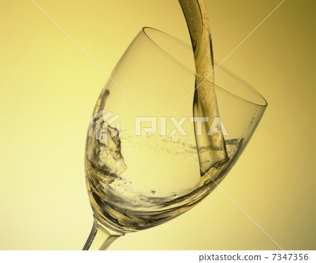 White wine poured into a wine glass 7347356