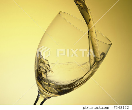 White wine poured into a wine glass 7348122