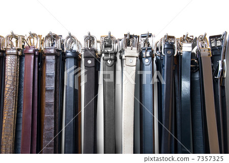 a lot of leather belts in store isolated on white 7357325