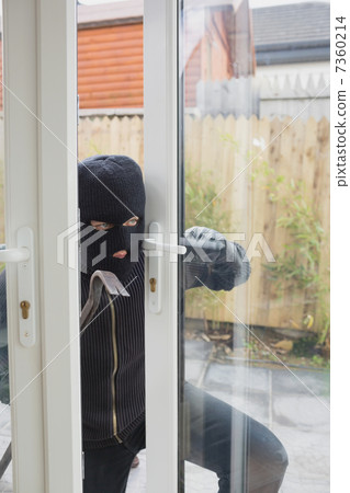 Burglar opening the terrace door 7360214