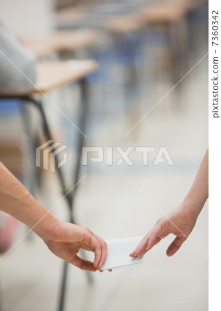 Two students cheating while doing a test Two students cheating while doing a test 7360342