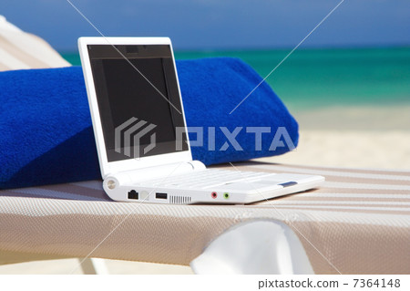 laptop and towel on the beach chaise longue laptop and towel on the beach chaise longue 7364148