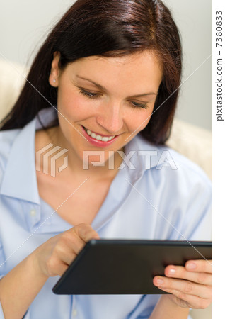 Portrait of smiling woman using digital tablet 7380833